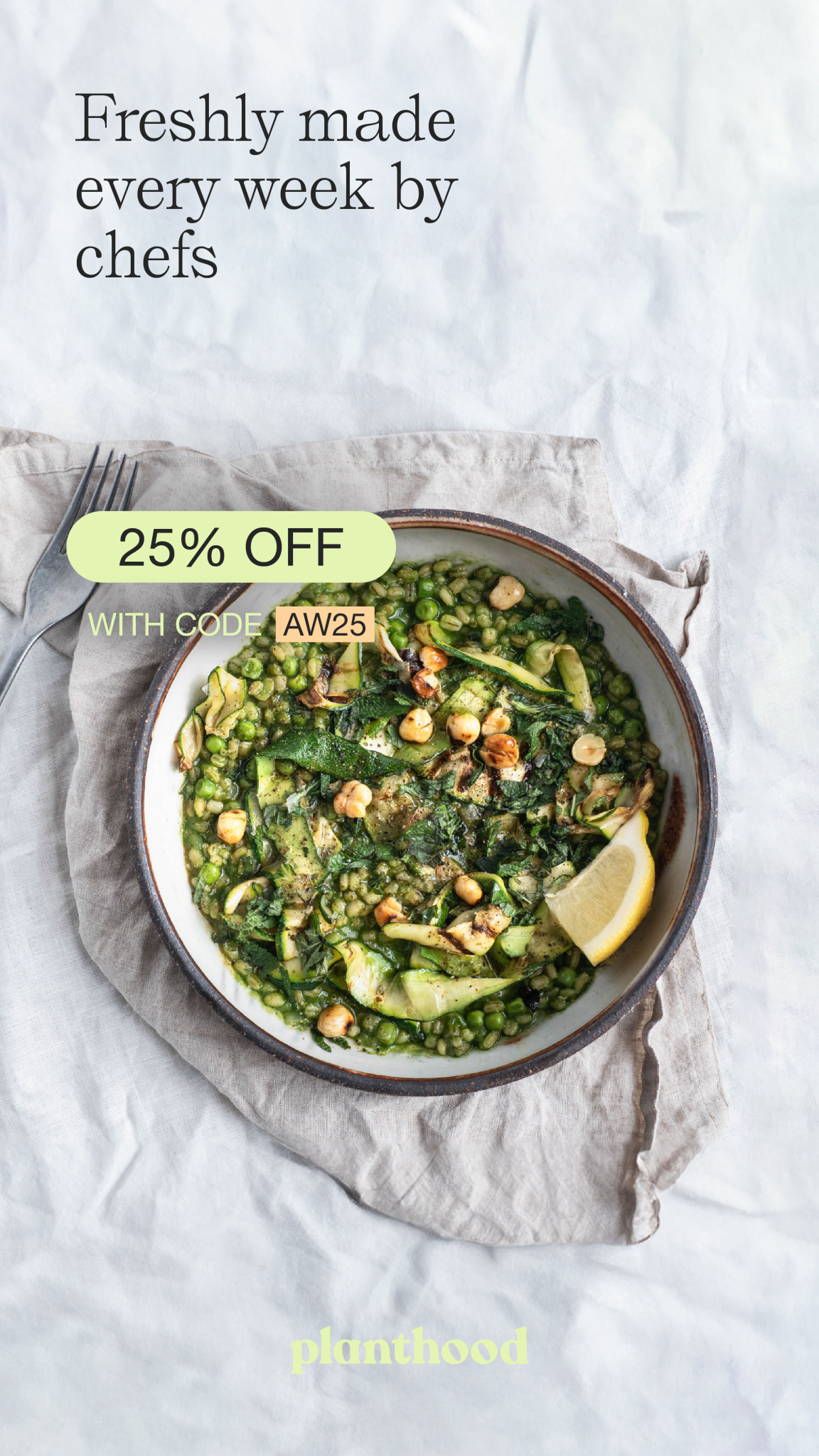 A beautifully arranged bowl of vibrant green risotto, featuring peas, spinach, and toasted hazelnuts, garnished with a lemon wedge. The creamy texture of the dish contrasts with the rustic, crumpled linen cloth underneath, enhancing the fresh, wholesome appeal of the meal.