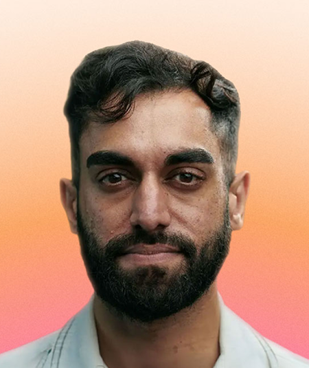 A close-up portrait of a man with a well-groomed beard and stylish hairstyle, dressed in a light-coloured shirt. The background features a smooth gradient, transitioning from soft peach at the top to vibrant pink below, creating a warm and inviting atmosphere.