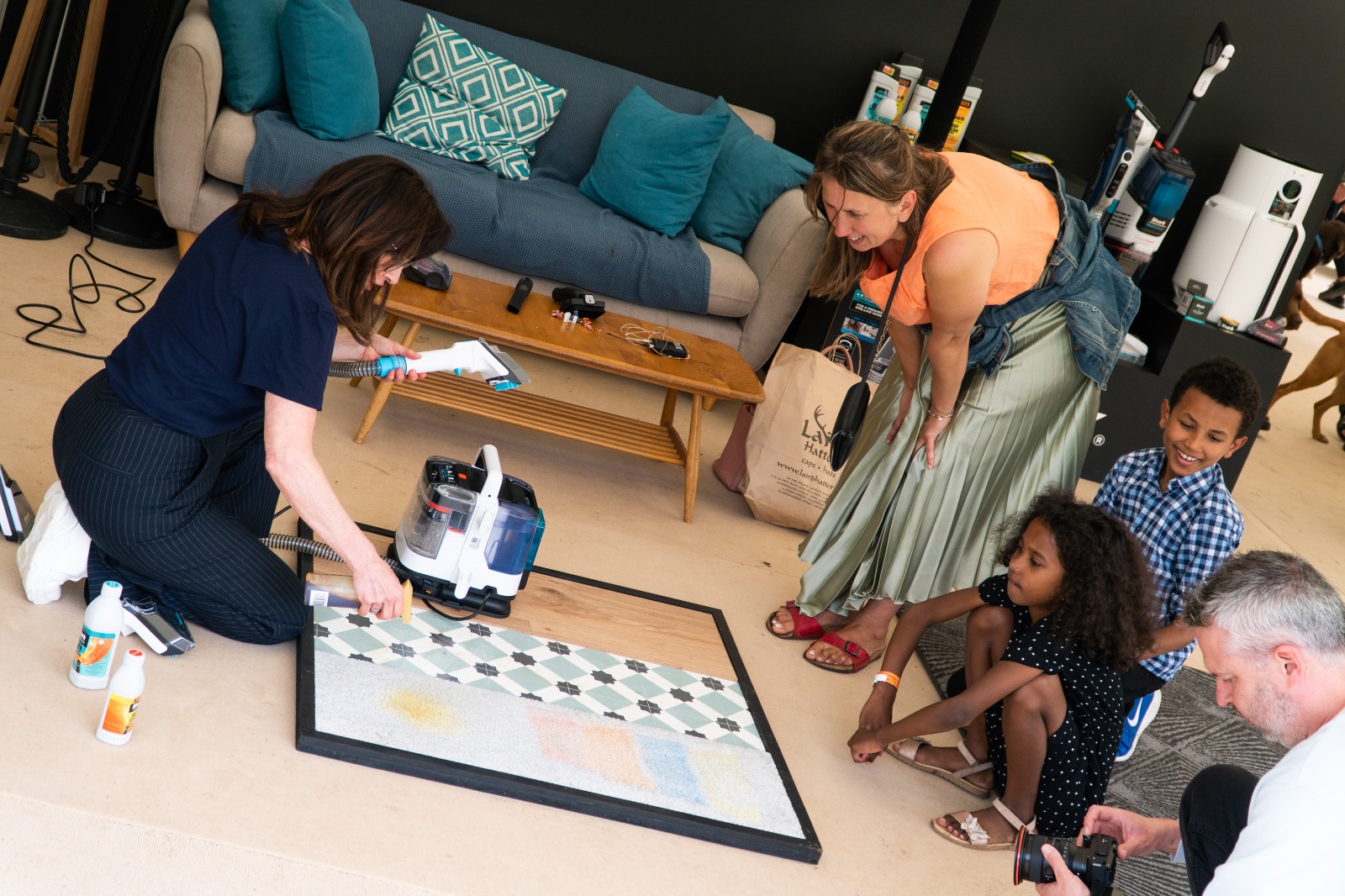 A group of people in a lounge setting receive a Shark product demo