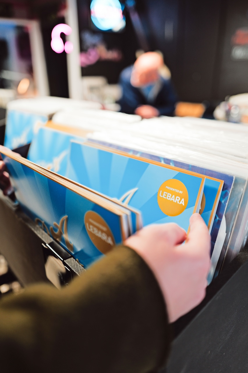 A hand is flicking through vinyl records